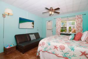 um quarto com uma cama, uma cadeira e uma janela em Tropic Terrace #23 - Beachfront Rental condo em St. Pete Beach