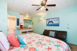 um quarto com uma cama e uma ventoinha de tecto em Tropic Terrace #23 - Beachfront Rental condo em St. Pete Beach