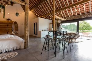 a bedroom with a bed and a bar with stools at De Hoeveschuur in Riemst