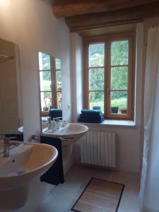 a bathroom with two sinks and two windows at Ca' del Rì in Gargnano