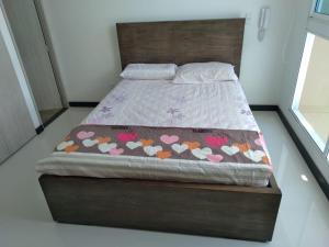 ein Bett mit einem hölzernen Kopfteil mit Herzen darauf in der Unterkunft Magnífico apartamento, Santa Marta sector Irotama in Santa Marta + 46 Fotos