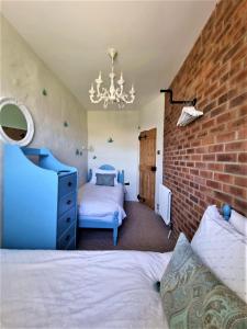 a bedroom with a bed and a brick wall at Byre Cottages & Log Cabin in Cardigan