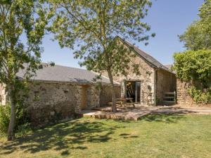 un antiguo edificio de piedra con un árbol en el patio en Gîte Varades, 3 pièces, 6 personnes - FR-1-306-847, en La Chapelle-Saint-Sauveur