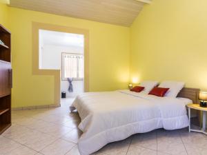 ein Schlafzimmer mit einem großen Bett und gelben Wänden in der Unterkunft Gîte Saint-Brevin-les-Pins, 4 pièces, 6 personnes - FR-1-306-934 in Saint-Brevin-les-Pins