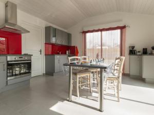 a kitchen with red cabinets and a table and chairs at Gîte Saint-Viaud, 4 pièces, 6 personnes - FR-1-306-1047 in Saint-Viaud