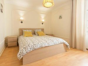 een slaapkamer met een groot bed met 2 gele kussens bij Gîte Nort-sur-Erdre, 4 pièces, 6 personnes - FR-1-306-915 in Nort-sur-Erdre