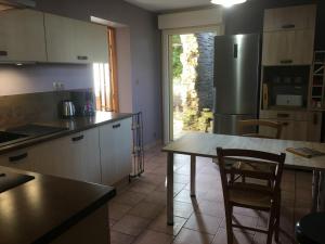 a kitchen with a table and a stainless steel refrigerator at Gîte Sionviller, 3 pièces, 4 personnes - FR-1-584-38 