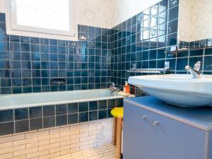 baño de azulejos azules con lavabo y bañera en Gîte Étain, 4 pièces, 6 personnes - FR-1-585-57, en Étain