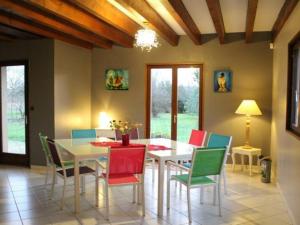 a dining room with a white table and colorful chairs at Gîte Bénaménil, 5 pièces, 6 personnes - FR-1-584-4 
