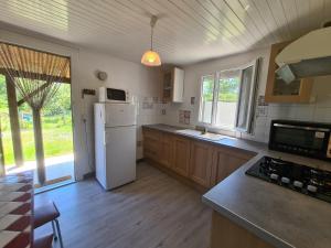 a kitchen with a white refrigerator and wooden floors at Gîte Baraize, 3 pièces, 4 personnes - FR-1-591-319 in Baraize