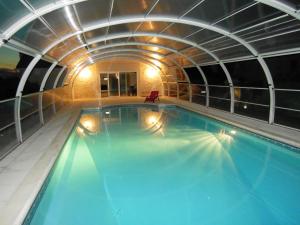 uma grande piscina num edifício com um túnel em Gîte Bouesse, 7 pièces, 14 personnes - FR-1-591-9 em Bouesse