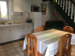 uma cozinha com uma mesa com uma toalha de mesa branca em Gîte Laître-sous-Amance, 2 pièces, 3 personnes - FR-1-584-68 