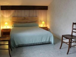 um quarto com uma cama com 2 cadeiras e 2 candeeiros em Gîte Laître-sous-Amance, 2 pièces, 3 personnes - FR-1-584-68 