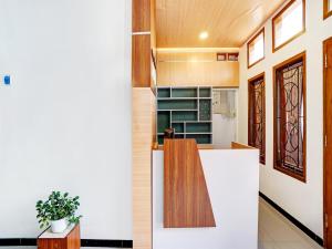 uma cozinha com bancadas brancas e detalhes em madeira em Super OYO 90383 Avisha Guest House Syariah em Malang
