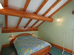 een slaapkamer met een bed in een kamer met houten plafonds bij Gîte Ferdrupt, 3 pièces, 6 personnes - FR-1-589-146 in Ferdrupt