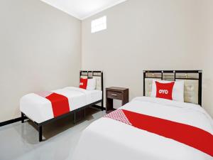 Llit o llits en una habitació de Super OYO 90383 Avisha Guest House Syariah