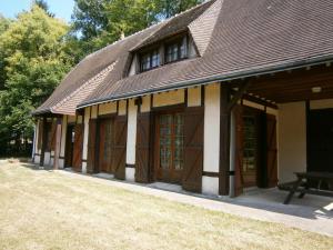 a building with brown doors and a bench in front at Maison de charme en pleine nature avec étang de pêche, proche d'Authon-du-Perche, animaux admis. - FR-1-581-1 in Authon-du-Perche