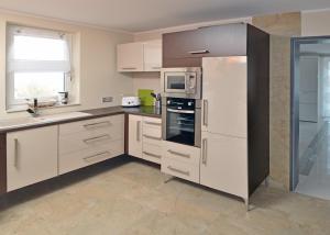 a kitchen with white cabinets and a refrigerator at Pension Schlossidyll in Wernigerode