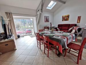 a dining room with a table and chairs and a couch at Gîte familial au cœur des gorges de la Loire avec équipements bébé et loisirs extérieurs - FR-1-582-238 in Lavoûte-sur-Loire
