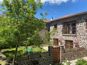 ein Steinhaus mit einem Baum davor in der Unterkunft Gîte à la ferme à Saint-Christophe-sur-Dolaison avec terrasse et chambres privatives - FR-1-582-284 in Saint-Christophe-sur-Dolaison
