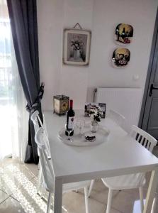 een witte eettafel met wijnflessen en glazen bij Themis Apartments in Sami