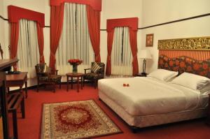 Habitación de hotel con cama, escritorio y mesa. en Royal Cocoon - Nuwara Eliya, en Nuwara Eliya