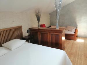 1 dormitorio con 1 cama y 1 silla en una habitación en Têtes à l'air, en Montils