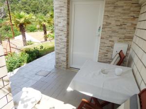 un tavolo bianco e sedie su un patio di Studio for short stay a Rabac