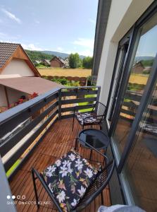 een balkon met 2 stoelen en een tafel met een kussen bij apartament BB in Podgórzyn