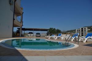 una pequeña piscina con sillas en Belvedere Apartments with Seaview, en Dobra Voda