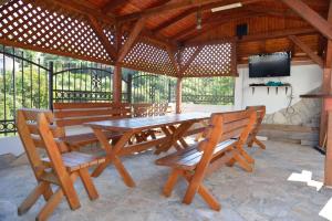 una mesa de picnic de madera y sillas en un pabellón en Belvedere Apartments with Seaview, en Dobra Voda 32 fotos más