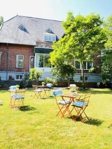 um grupo de mesas e cadeiras num pátio em aday - Aalborg mansion - Open bright apartment with garden em Aalborg