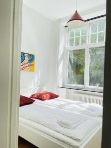 uma cama branca num quarto com uma janela em aday - Aalborg mansion - Open bright apartment with garden em Aalborg