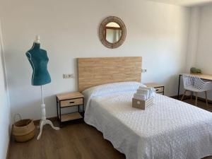 1 dormitorio con cama, maniquí y espejo en Albergue San Pedro, en Corcubión