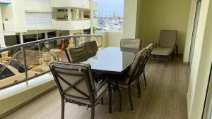 a table and chairs on a balcony with a boat at Capaldi Luxury Holiday Rentals Puerto Marina Benalmadena in Benalmádena