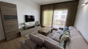 ein Wohnzimmer mit einem großen Sofa und einem TV in der Unterkunft Capaldi Luxury Holiday Rentals Puerto Marina Benalmadena in Benalmádena