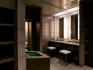 a bathroom with a tub and two sinks and two stools at Fukuoka U-BELL Hotel in Fukuoka