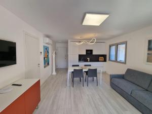 ein Wohnzimmer mit einem Sofa und einem Tisch in der Unterkunft Wave Tower Residence in Lignano Sabbiadoro