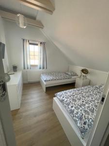 a bedroom with two beds and a window at Apartament Biały Domek in Władysławowo