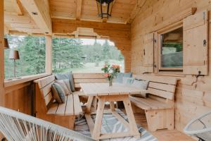 a wooden cabin with a table and benches at mei chalet - DAS BARBARA in Leutasch