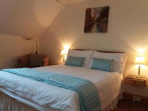 a bedroom with a large white bed with two lamps at Osnok in Tenby