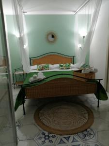 a small bedroom with a bed with a green blanket at Maison C&G in Pachino