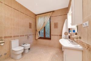 een badkamer met een toilet, een wastafel en een raam bij Blaguna Eco Complex in Varna