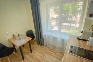 a small table and chairs in a room with a window at Peter's Market apartment in Liepāja
