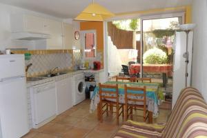 een keuken met een tafel en stoelen en een keuken met een raam bij Maison au centre de St Jean du Gard in Saint-Jean-du-Gard