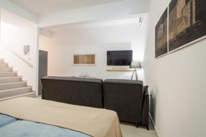 a living room with a couch and a television at Eleni's Studio in Heraklio Town