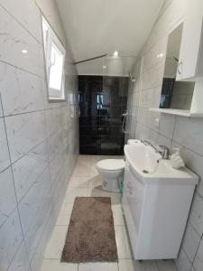 a white bathroom with a sink and a toilet at Cityview Unique Apartment Ohrid in Ohrid