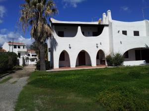 um edifício branco com uma palmeira em frente em Appartamento Con Accesso Spiaggia em Pula