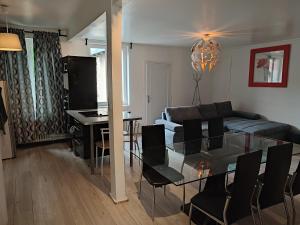 Appartement Cosy et Lumineux في تور: غرفة معيشة مع طاولة زجاجية وأريكة