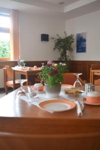 una mesa con un plato de comida y flores en ella en HOTEL BIKE & HIKE, en Obersuhl
